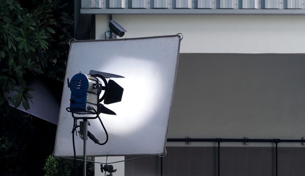 Big LED studio light equipment with tripod for video production shooting at outdoor location.