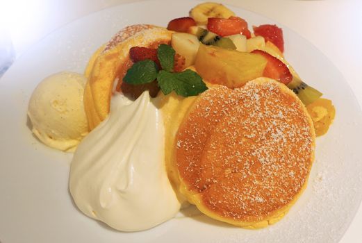 Japanese pancake and many kind of fruits include banana strawberry kiwi orange and serve with ice-cream.