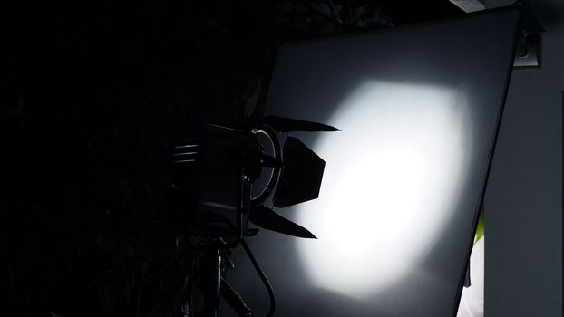 Big LED studio light equipment with tripod for video production shooting at outdoor location.