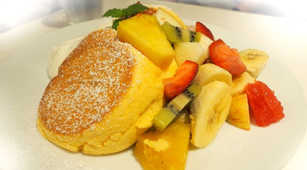 Japanese pancake and many kind of fruits include banana strawberry kiwi orange and serve with ice-cream.