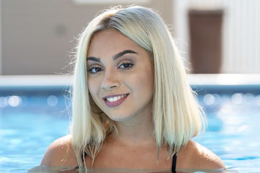 A gorgeous young blonde model poses in a bikini while enjoying a summers day
