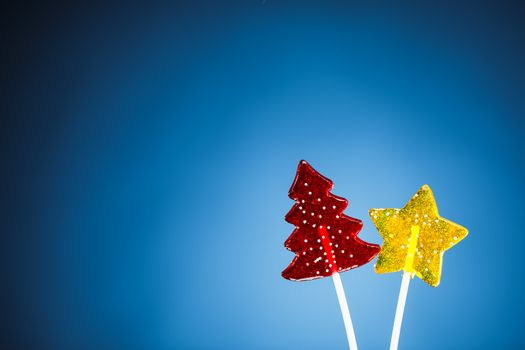 red Christmas tree and yellow star candy, blue background