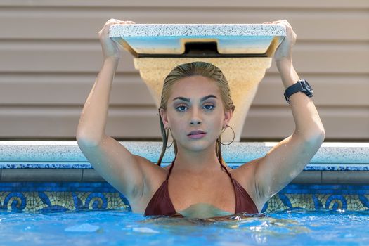 A gorgeous young blonde model poses in a bikini while enjoying a summers day