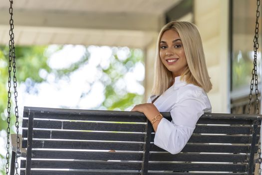 A gorgeous young blonde model poses outdoors while enjoying a summers day