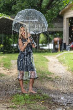 A gorgeous young blonde model poses while getting wet outdoors as she enjoys a summers day