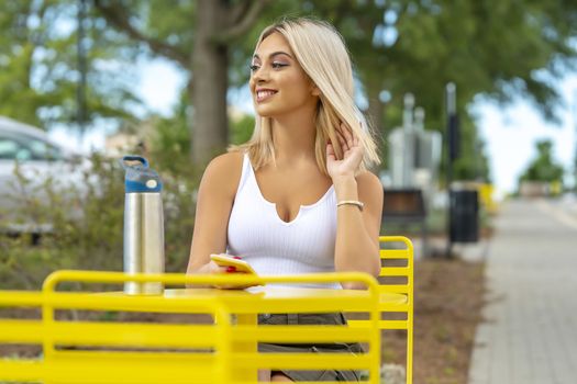 A gorgeous young blonde model poses outdoors while enjoying a summers day
