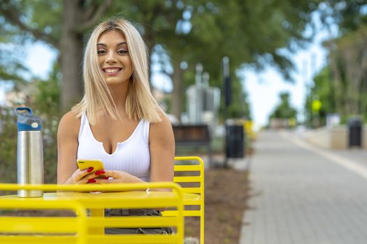 A gorgeous young blonde model poses outdoors while enjoying a summers day
