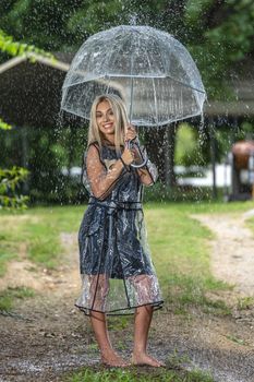 A gorgeous young blonde model poses while getting wet outdoors as she enjoys a summers day