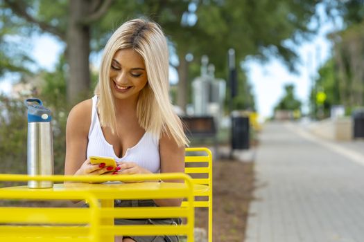 A gorgeous young blonde model poses outdoors while enjoying a summers day