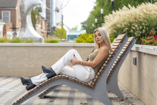 A gorgeous young blonde model poses outdoors while enjoying a summers day