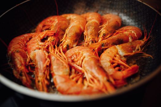 fried red shrimps with hot oil on pan