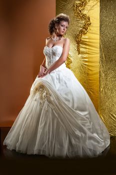 Young woman in a wedding dress on a studio background