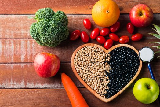 World food day, Top view of various fresh organic fruit and vegetable in heart plate and doctor stethoscope, studio shot on wooden table, Healthy vegetarian food concept