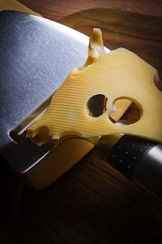 Cheese and cheese knife on wooden cutting board