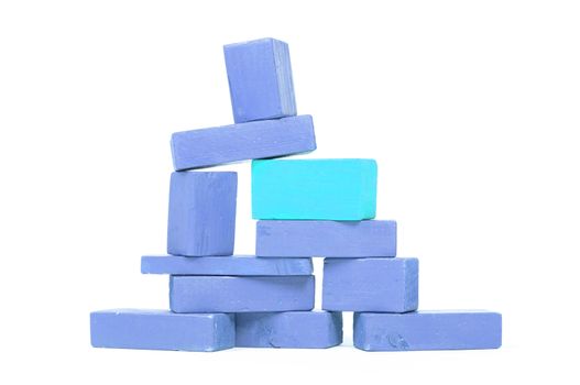 Vintage blue building blocks isolated on white background, one standing out