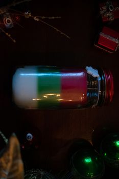 A Red Green and White Christmas Candle Surrounded by Various Holiday Props