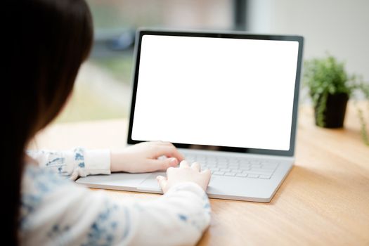 A young female child uses a computer in remote learning for her school work