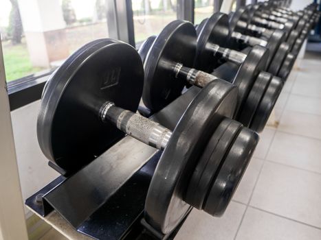 dumbbell set. Close up many metal dumbbells on rack in sport fitness center