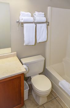 Fragment of bathroom with fresh towels. Bathroom with toilet and bath tub
