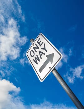 One way road sign on blue sky background