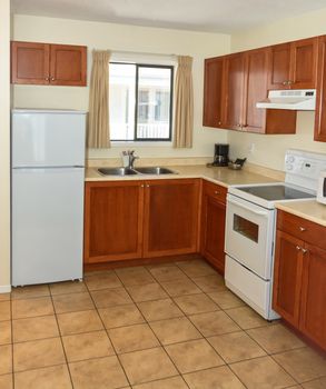 Kitchen with wooden cabinets, fridge, and electric stove