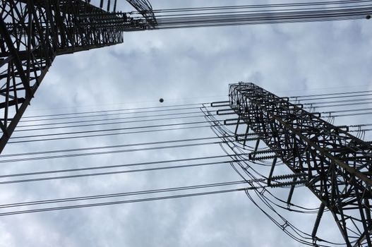 Close up view , high voltage power lines station. High voltage electric transmission pylon silhouetted tower.