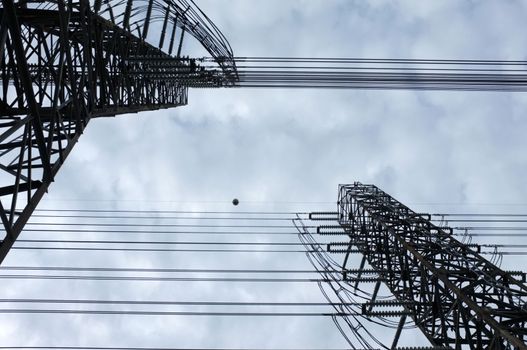 Close up view , high voltage power lines station. High voltage electric transmission pylon silhouetted tower.