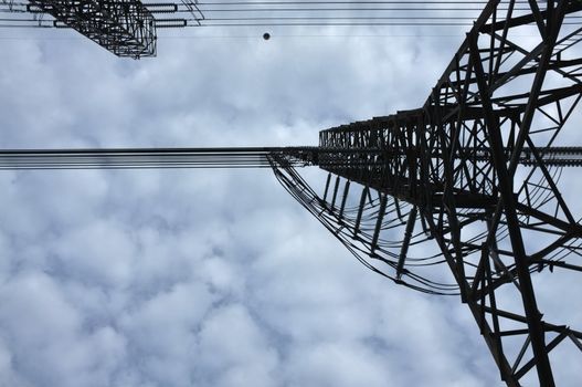 Close up view , high voltage power lines station. High voltage electric transmission pylon silhouetted tower.