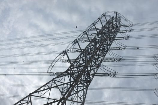 Close up view , high voltage power lines station. High voltage electric transmission pylon silhouetted tower.