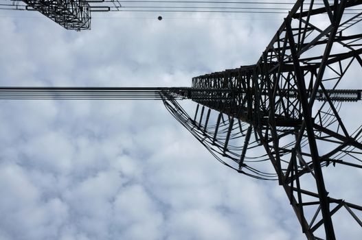 Close up view , high voltage power lines station. High voltage electric transmission pylon silhouetted tower.