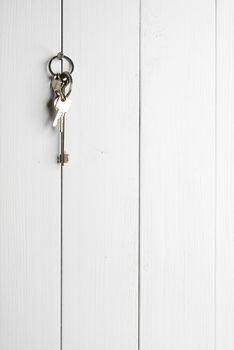 a bunch of keys hanging on a white wooden wall