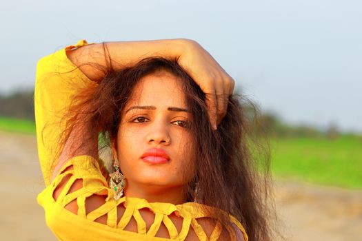 closeup of A fashionable Indian model girl in yellow top, head shot