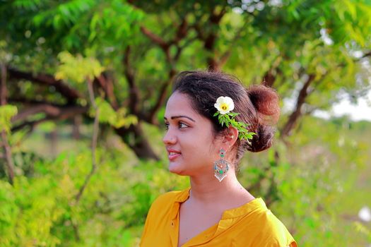 Photo of an Indian young girl with flower in creative hairs