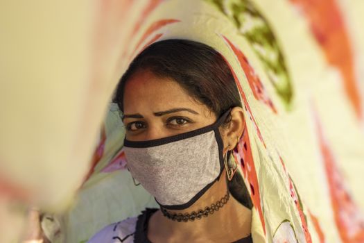 An Indian young girl creative photo taken with a scarf and wearing face mask Protection against disease, coronavirus.