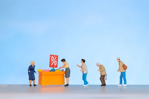 Miniature people , Shoppers with discount tray for shopping discounted items