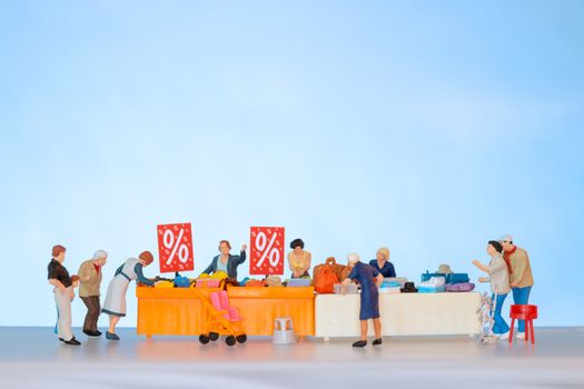 Miniature people , Shoppers with discount tray for shopping discounted items