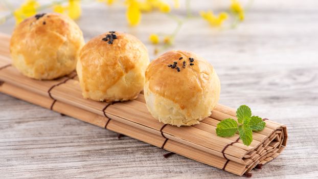 Moon cake yolk pastry, mooncake for Mid-Autumn Festival holiday, top view design concept on bright wooden table with copy space