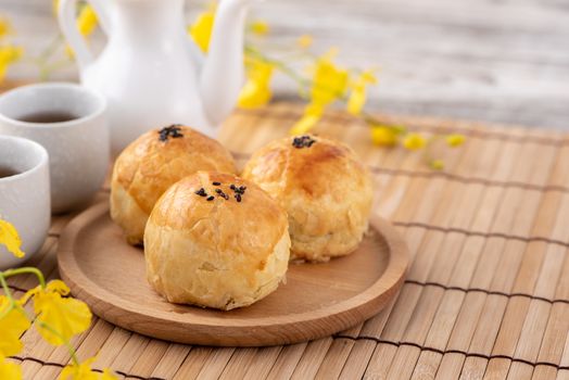 Moon cake yolk pastry, mooncake for Mid-Autumn Festival holiday, top view design concept on bright wooden table with copy space