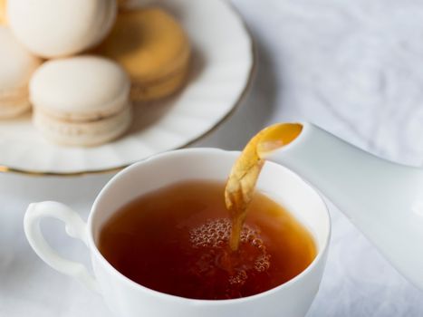 Snapshot of tea and delicious tea cakes poured out of the jug on the table.