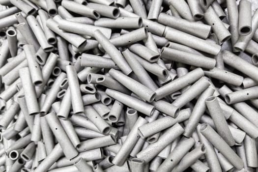 a pile of small steel sand blasted tubes - close-up with selective focus and blur.