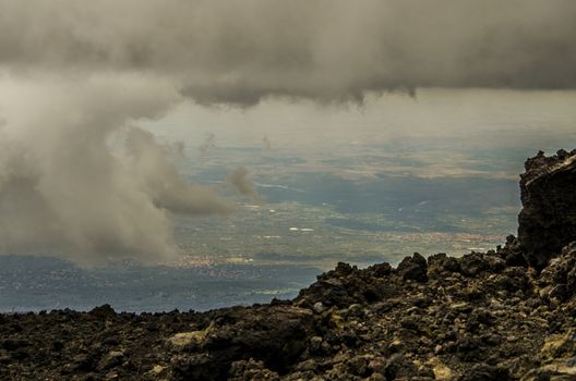 View of Sicilian territory between clouds from the top of Etna volcano