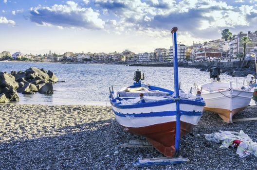 Sicilian coast at the height of the city of giardini naxos seen in the background and fishing boats sicily italy