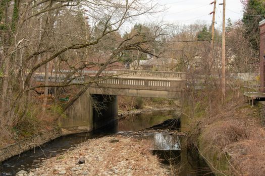 An Old Concrete Bridge in Suburban Pennsylvania Surrounded by Bare Trees With Water Running Underneath It