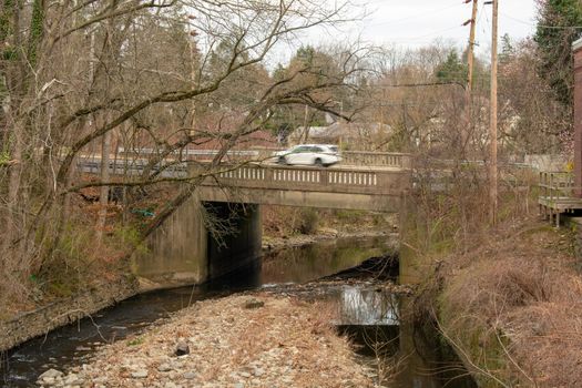 An Old Concrete Bridge in Suburban Pennsylvania Surrounded by Bare Trees With Water Running Underneath It