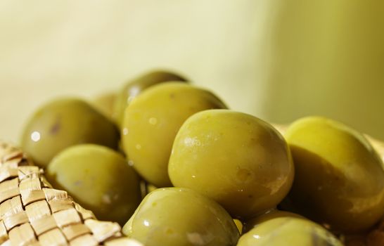 Group of green olives on straw -studio shot