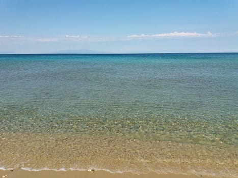 Clear Mediterranean Sea in Greece, blue and green water, beach for resting.