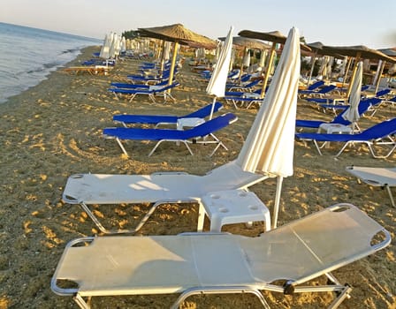 Sunbeds at the mediteraneann sea, Greek beach at sunrise