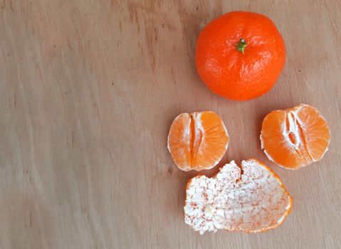 Peeled clementines on a wooden background, Copy space