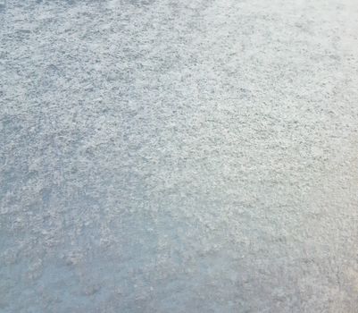 Snowy texture on the hood of a car.