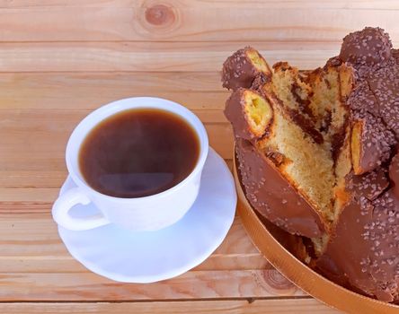 Panettone with a coffee on a wooden background.